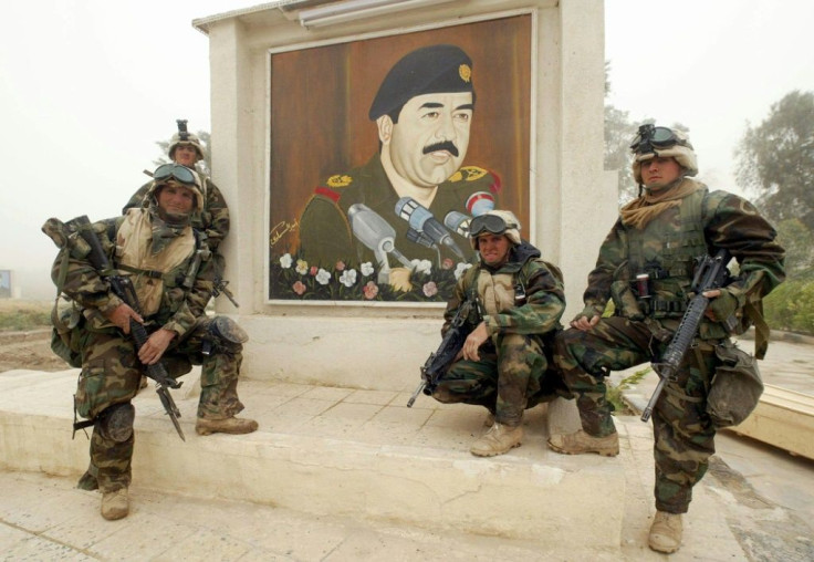 Marines from the 2nd Battalion, 8th Regiment pose next to a mural of Iraqi president Saddam Hussein found after taking control of a hospital allegedly used for military purposes by Iraqi forces near the Iraqi city of Nasiriyah in March 2003