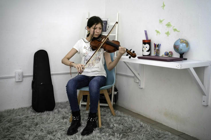 Paola, one of thousands of Mexican children who have lost a parent to Covid-19, plays the violin at her home in the eastern state of Veracruz
