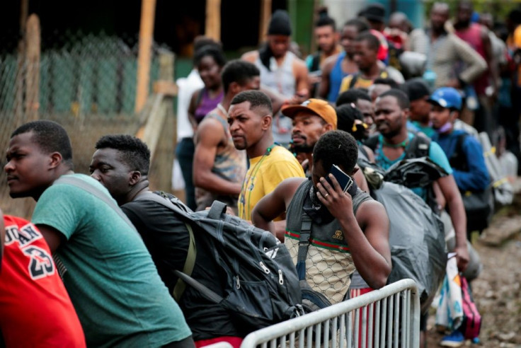 Migrants queue up to register their official entry into Panama at the village of Bajo Chiquito, close to the border with Colombia