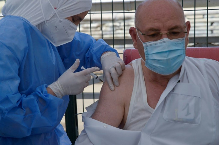 An Algerian medic administers a COVID-19 vaccine dose in front of the El-Kebir mosque in the capital Algiers