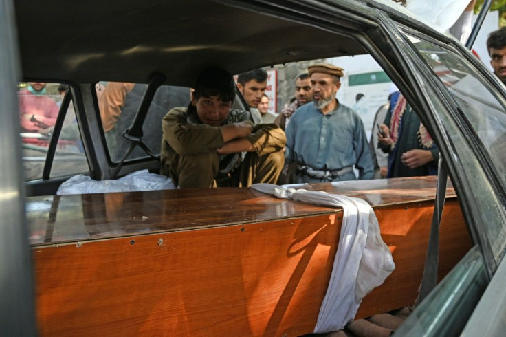 A relative mourns inside a car next to the coffin of a victim of the August 26 twin suicide bombs, which killed scores of people including 13 US troops outside Kabul airport