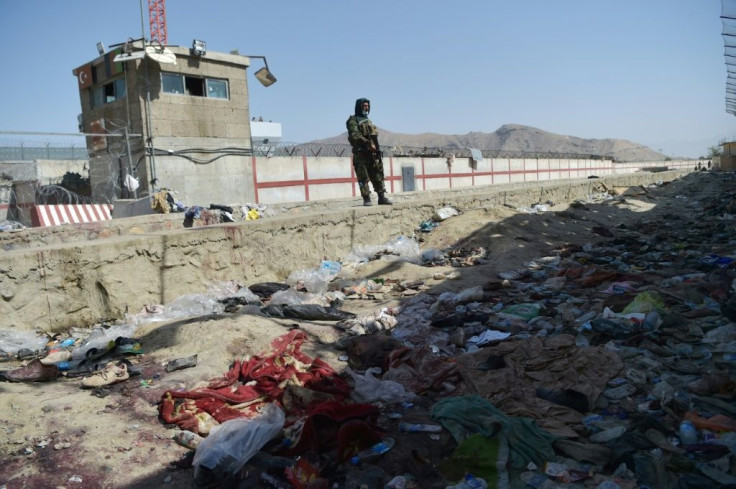 A Taliban fighter stands guard at the site of the suicide bombing at Kabul airport