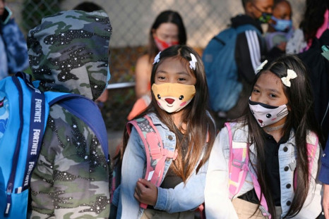 Students and parents arrive masked for the first day of the school year at an elementary school in Los Angeles