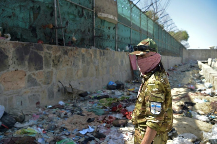 A Taliban fighter stands guard at the site of the deadly suicide attack at Kabul airport