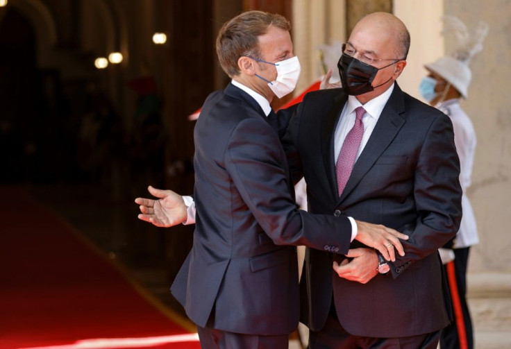 Iraqi President Barham Saleh (R) welcomes his French countepart Emmanuel Macron in Baghdad on August 28