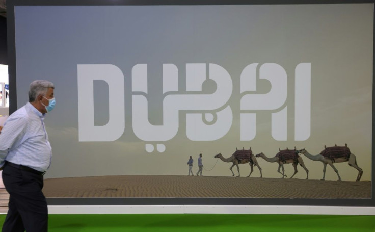 A visitor walks past a Dubai billboard at the Arabian Travel market exibition in the Gulf emirate, on May 17, 2021
