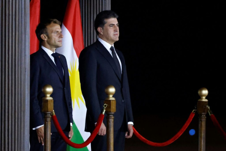 French President Emmanuel Macron (L) stands with President of Iraq's autonomous Kurdistan Region Nechirvan Barzani during a welcome ceremony at Arbil Airport in Arbil, the capital of Iraq's northern autonomous Kurdish region