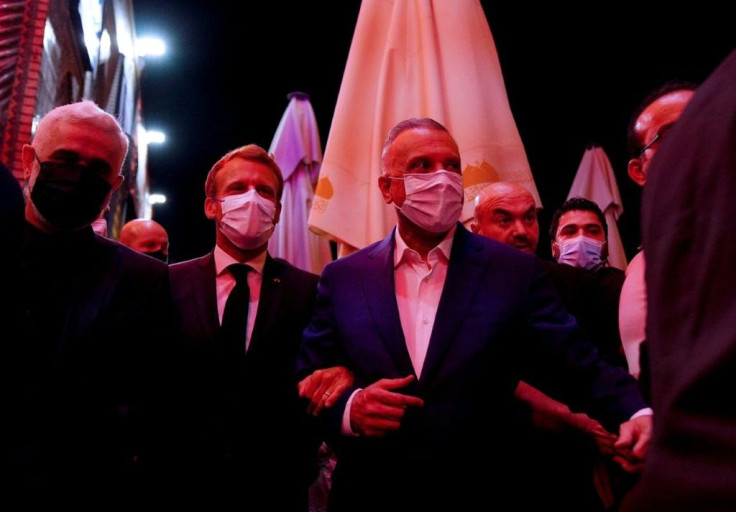 Iraqi Prime Minister Mustafa al-Kadhemi (C-R) and French President Emmanuel Macron (C-L) visiting the shrine of Imam Musa Al-Kadhim in the northern district of Kadhimiya of Iraq's capital Baghdad