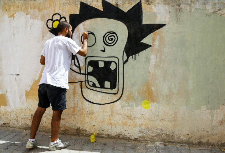 Graffiti artist Kaisser Grojja, also known as 'Wolf Gang', works on a mural in Sidi Bouzid in central Tunisia