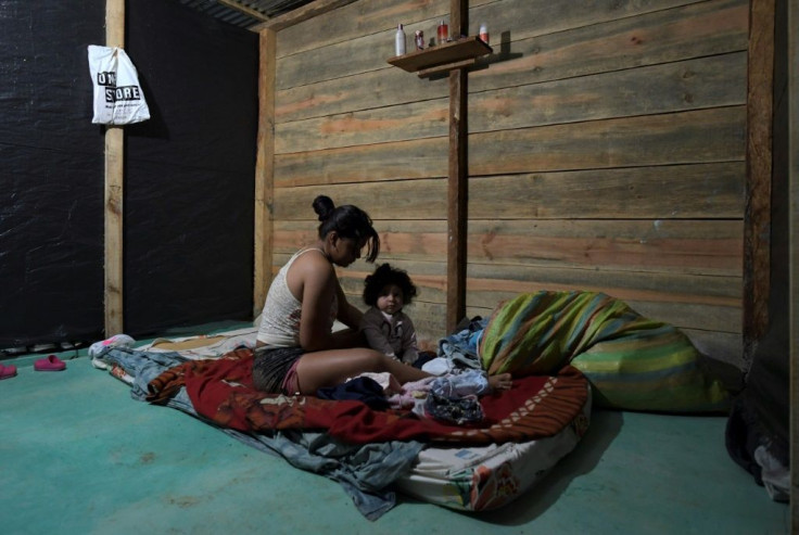 Colombian coca leaf collector Karen Palacios, 20, gets ready with her daughter for her work shift at a coca field -- she has been doing this work since she was a teenager