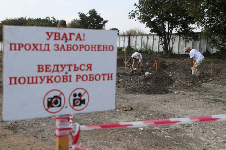 People work on the site of mass graves site unearthed near Odessa airport in Ukraine