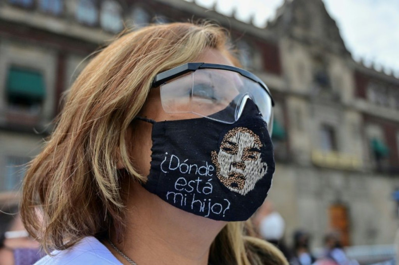 A woman wears a face mask reading 'Where is my son?' at a protest in Mexico City