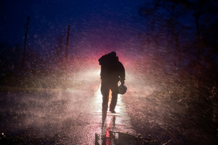 Montegut fire chief Toby Henry  walks back to his firetruck after helping cut through trees on the road in Bourg, Louisiana on August 29, 2021