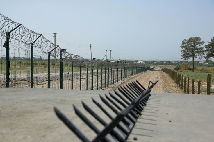 A barbed wire fence near a police checkpoint between Uzbekistan and Afghanistan