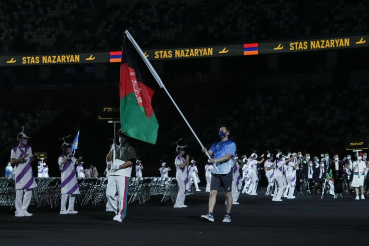 A Tokyo 2020 volunteer symbolically carried the Afghan flag during the Games opening ceremony
