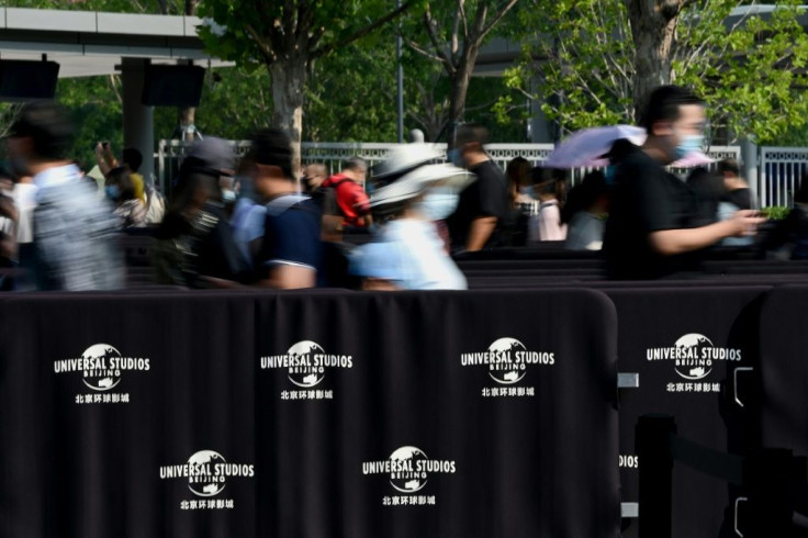 People queue to enter Universal Studios in Beijing during a trial run of the theme park