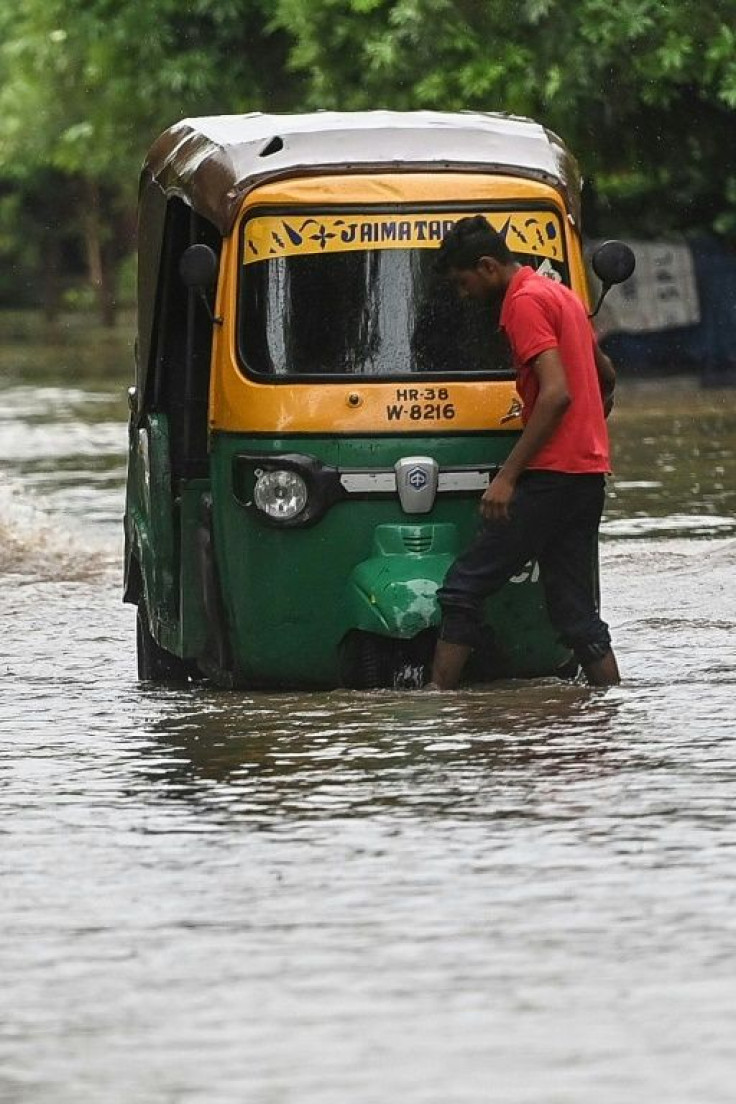 A driver checks his vehicle after it got stuck in water in Faridabad