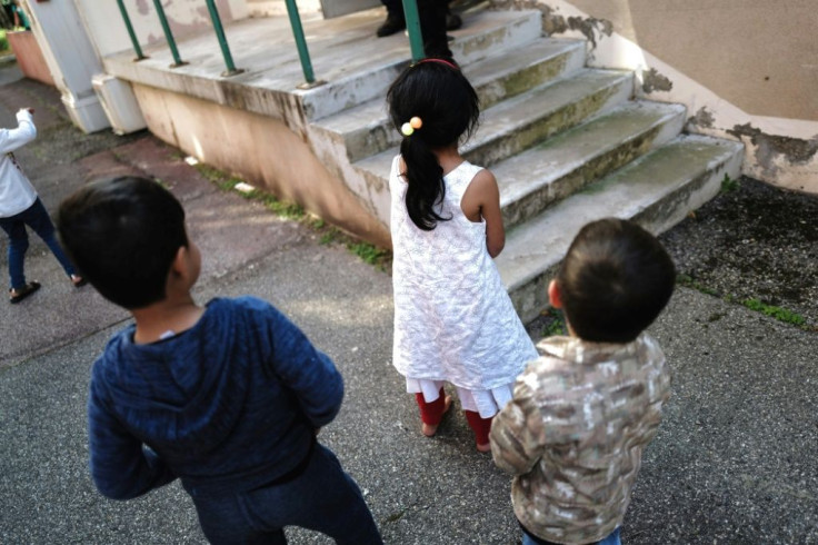 Children play outside of a building as Afghan refugee families arrive in Villeurbanne, near Lyon