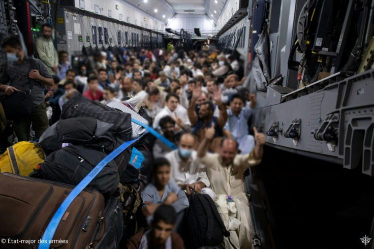 People board a French military transport aircraft in Kabul to fly to the air base of Al Dhafra near Abu Dhabi, and then to France on August 26, 2021 following the Taliban takeover