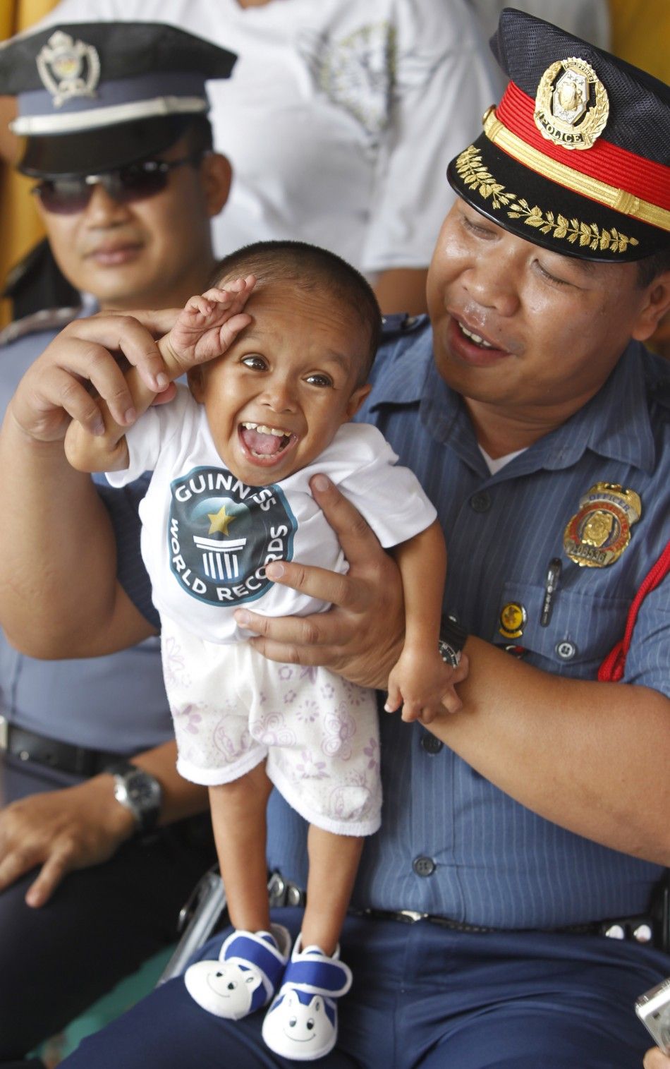 A police officer holds on his lap Junrey Balawing, the quotWorld039s Shortest Living Manquot declared by the Guinness World Records in Sindangan