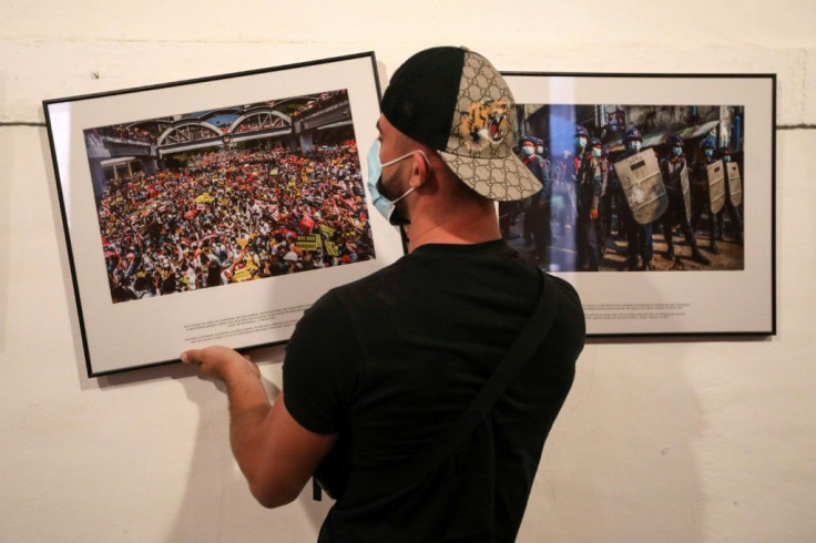 A worker hangs photos for the exhibition 'Anonymous photographer in Myanmar' ahead of the 'Visa pour l'Image' international photojournalism festival in Perpignan, France