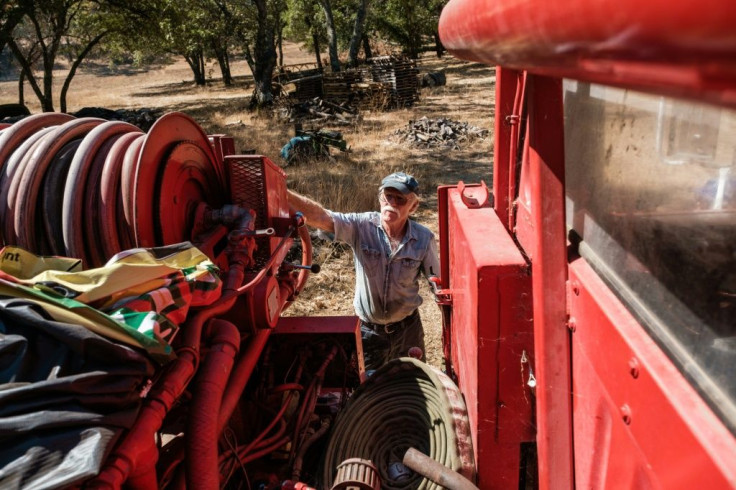 Randy Dunn checks the hose on a fire truck he has purchased to protect his vinyard from California wildfires