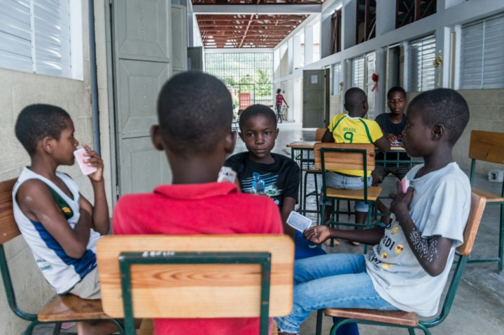 Children play cards at a school in the Haitian town of Chardonnieres that has been turned into a shelter for people left homeless by an August 14 earthquake