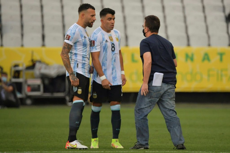 An employee of Brazil's National Health Surveillance Agency (ANVISA) argues with Argentina players Nicolas Otamendi (left) and Marcos Acuna after their World Cup qualifier with Brazil was halted