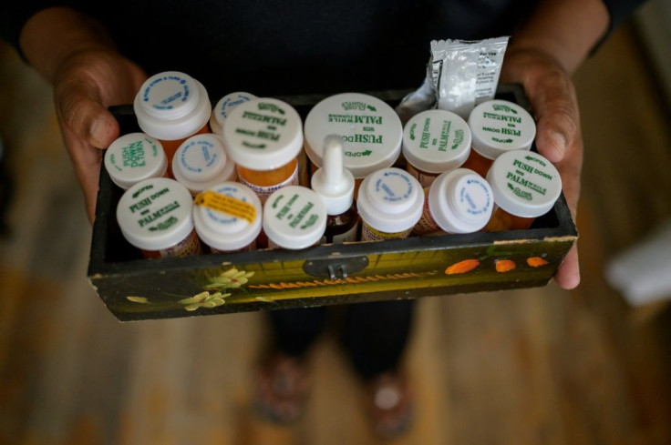 Rubiela Arias shows medications she takes for illnesses contracted after cleaning the 9/11 site, at her home in Queens, New York, on May 27, 2021
