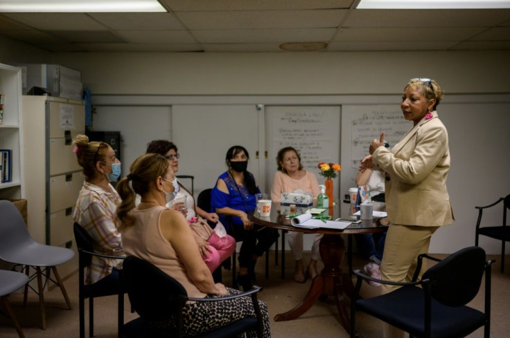 Social worker Rosa Bramble (right), leader of a support group for Hispanic workers who helped clean Ground Zero after 9/11, talks to them at her office in the New York borough of Queens, on June 10, 2021