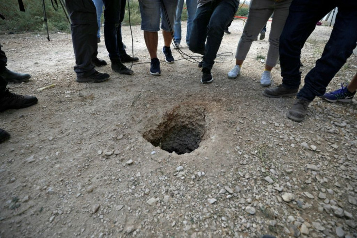 Police and journalists gather around a hole used by six Palestinian prisoners to escape from the Gilboa Prison after they dug a tunnel beneath a sink