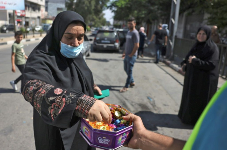 A Palestinian man in Gaza distributes sweets to celebrate the escape of six Palestinians from an Israeli prison