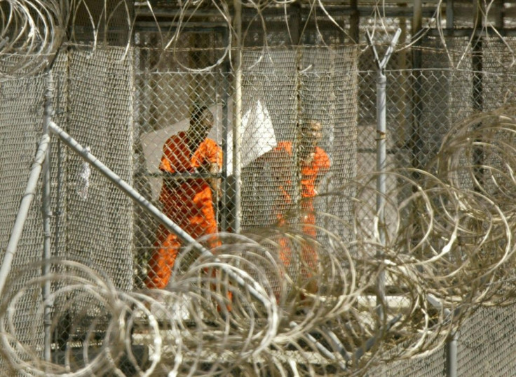 In this file photo taken on January 27, 2002, a detainee from Afghanistan cleans himself as another detainee looks out from his enclosure at the US naval base in Guantanamo Bay, Cuba