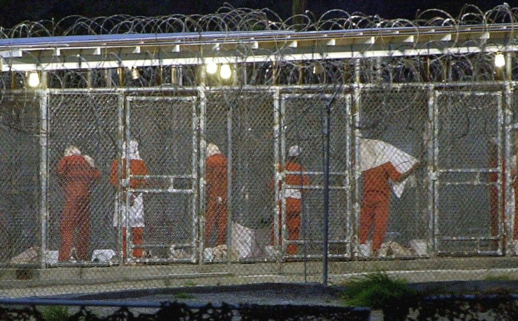 In this file photo taken on March 4, 2002, detainees prepare for the evening prayer at Camp X-Ray in Guantanamo Bay, Cuba by facing toward Mecca