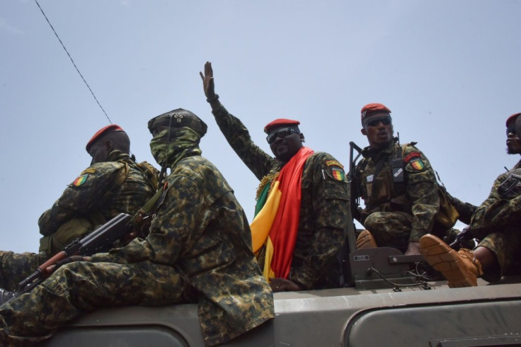 Coup leader Lieutenant Colonel Mamady Doumbouya, centre, waving to the crowd as he arrived at parliament on Monday for a meeting with outgoing ministers