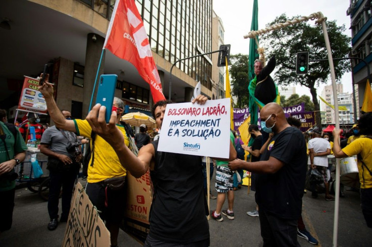 A man holds a banner that reads "Bolsonaro thief, impeachment is the solution" during a demonstration against Brazilian President Jair Bolsonaro in Rio de Janeiro
