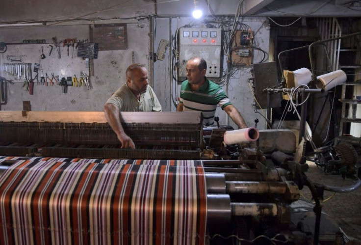 Syrian men work at a workshop in Aleppo. Syrians in government-held areas have had to adapt their lives at home and work around power cuts of up to 20 hours a day