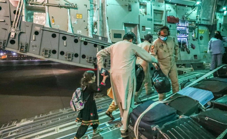 This undated handout picture provided by Qatar's Government Communications Office on August 21, 2021 shows evacuees from Afghanistan arriving at Al-Udeid airbase outside the capital Doha