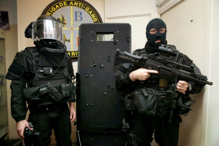 French BRI police commandos pose with the bullet-riddled Ramses shield used in the raid