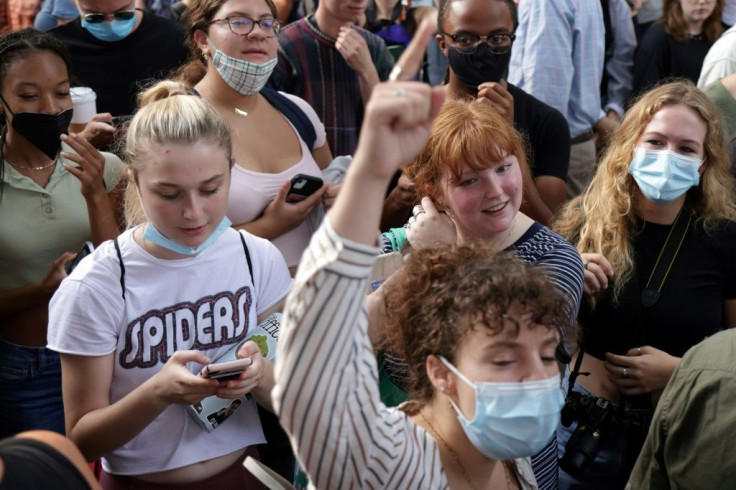 A crowd of onlookers celebrated as the statue of Confederate General Robert E. Lee was taken down in Richmond, Virginia