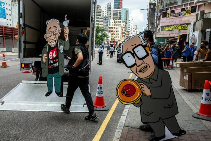Police officers from the National Security Department take away exhibits featuring images of former Chinese Communist Party leader Zhao Ziyang and pro-democracy activist Szeto Wah after raiding the June 4 museum