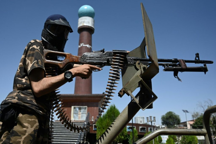 A Taliban fighter seen in front of Massoud Circle, a monument in Kabul named after the famed guerrilla commander