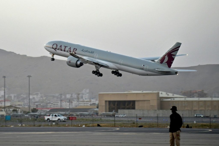 A Qatari security personnel stands guard as a Qatar Airways aircraft takes off from the airport in Kabul on September 9, 2021