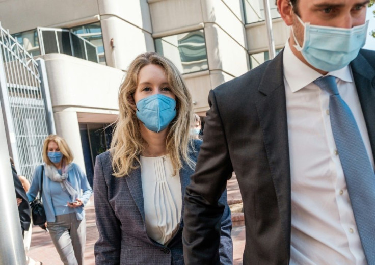Elizabeth Holmes (L), founder and former CEO of blood testing and life sciences company Theranos, leaves the courthouse with her husband Billy Evans after the first day of her fraud trial in San Jose, California