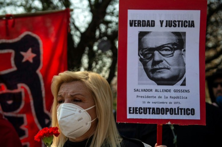 A woman holds a sign showing Chilean president Salvador Allende and the words 'Truth and justice. Political executed' during a tribute to victims of the military dictatorship (1973-1990)