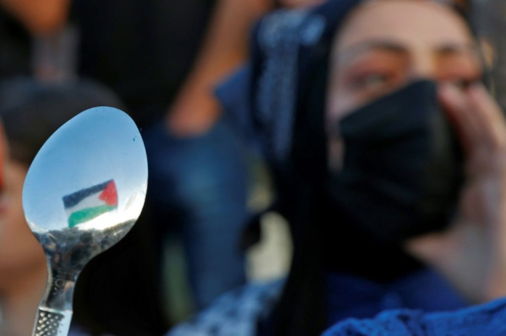 Arab-Israeli protesters lift spoons, reportedly the digging tool used by six Palestinians who escaped from Israel's Gilboa prison, as they demonstrate in the city of Umm al-Fahm in northern Israel on September 10, 2021