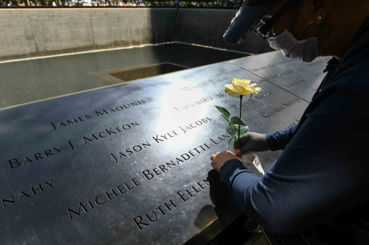 Linda Terry places a flower near the name of a friend and former client, who died on 9/11 at the National 9/11 Memorial & Museum on September 10, 2021