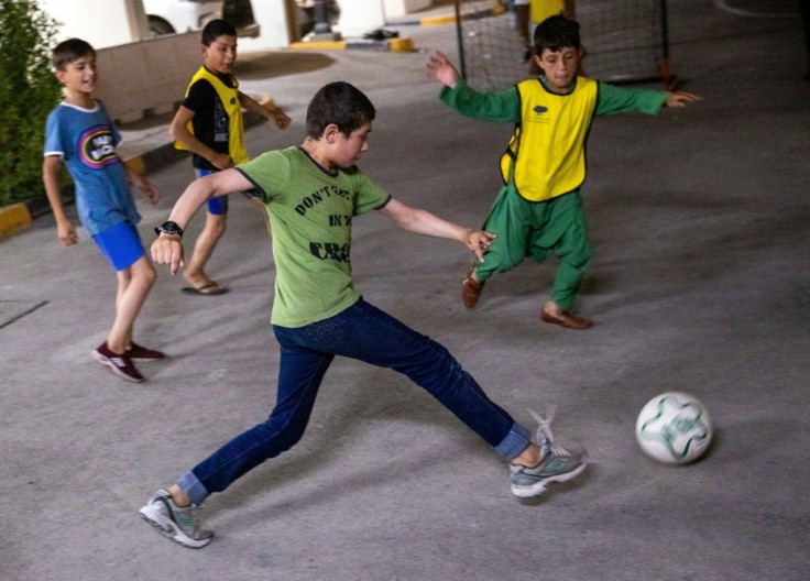 A group of unaccompanied Afghan children play football in Doha where a charity is caring for them until they can find their relatives