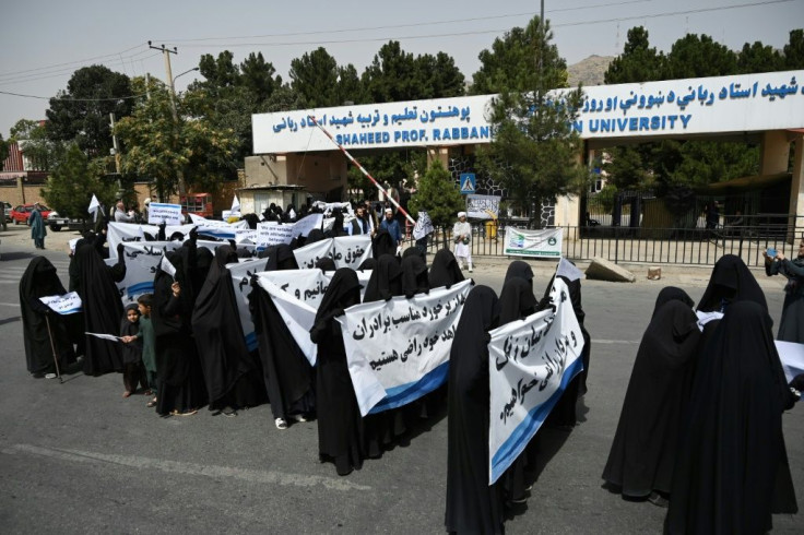 Veiled women held banners and placards while marching during a pro-Taliban rally outside the Shaheed Rabbani Education University in Kabul on September 11, 2021. Afghan women wearing full face veils sat in rows at a Kabul university lecture theatre Saturd