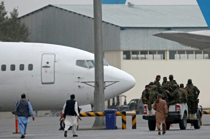 Taliban fighters patrol in a vehicle along the tarmac at the airport in Kabul
